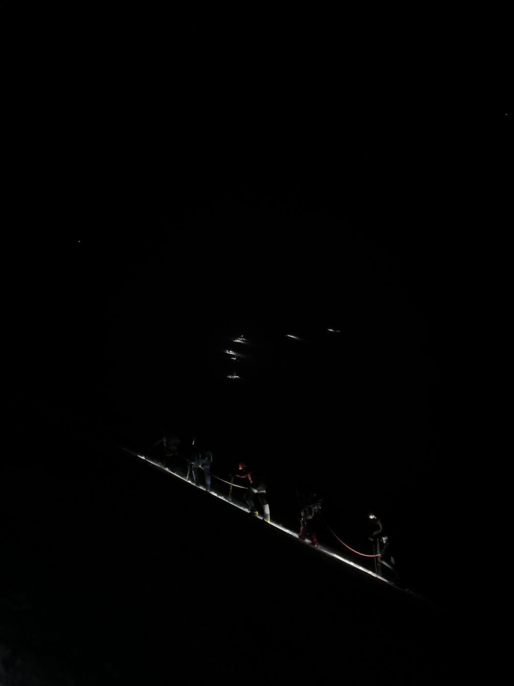 A line of headlamps on the Cotopaxi glacier in the dark.
