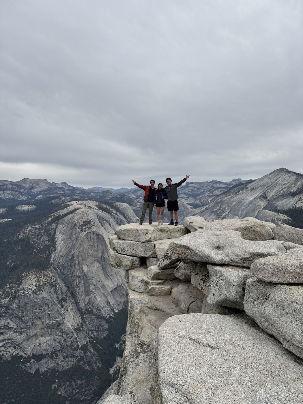Three of us on the summit of Half Dome with our arms up.
